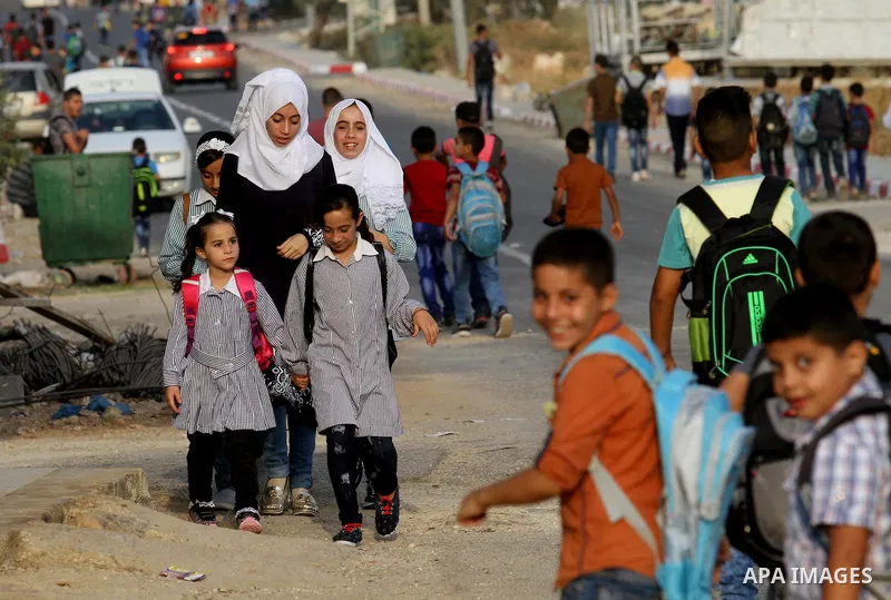 Palestinian students return back to their school in the morning of the first day of the new year study, in the West Bank city of Nablus, on August 28, 2016. Photo by Nedal Eshtayah