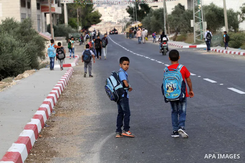 Palestinian students return back to their school in the morning of the first day of the new year study, in the West Bank city of Nablus, on August 28, 2016. Photo by Nedal Eshtayah