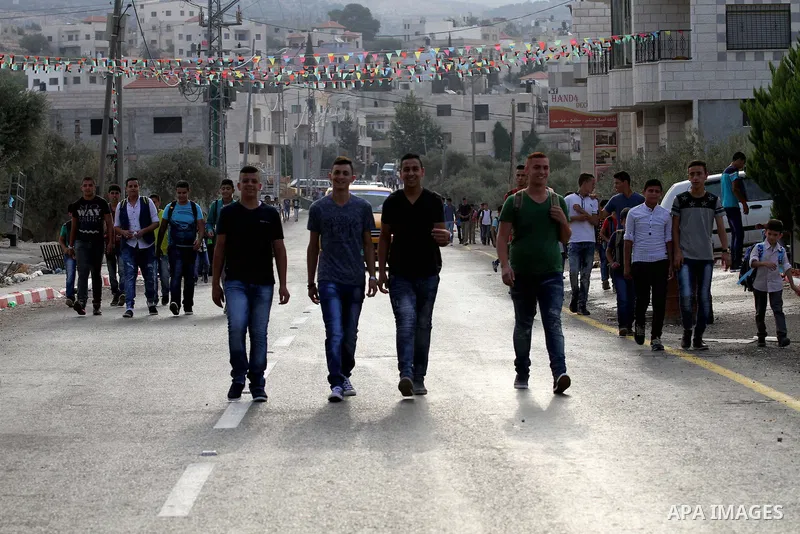 Palestinian students return back to their school in the morning of the first day of the new year study, in the West Bank city of Nablus, on August 28, 2016. Photo by Nedal Eshtayah