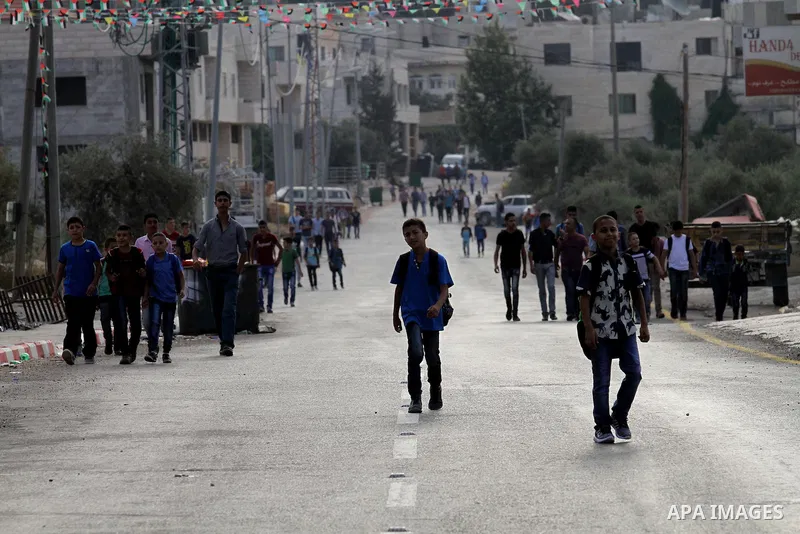 Palestinian students return back to their school in the morning of the first day of the new year study, in the West Bank city of Nablus, on August 28, 2016. Photo by Nedal Eshtayah