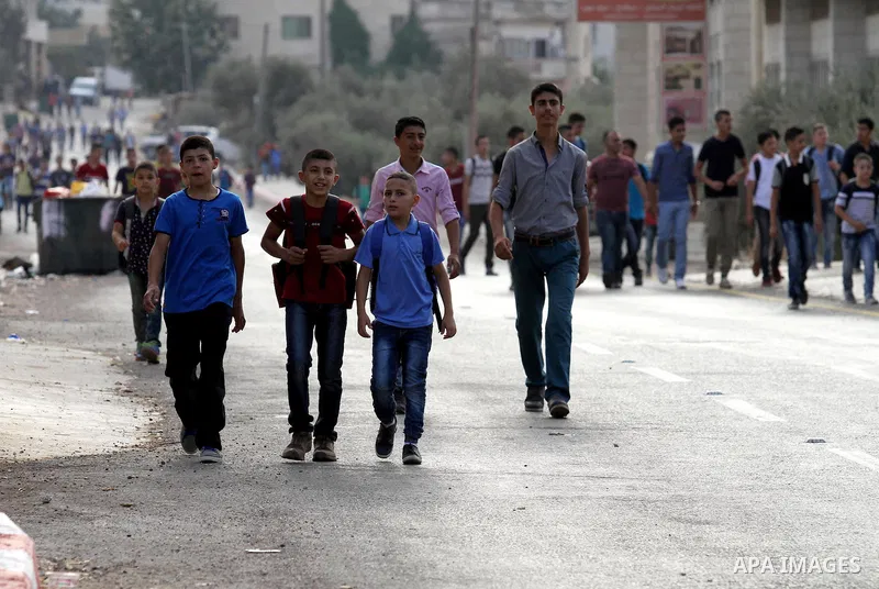 Palestinian students return back to their school in the morning of the first day of the new year study, in the West Bank city of Nablus, on August 28, 2016. Photo by Nedal Eshtayah