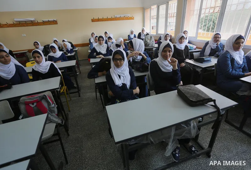 Palestinian schoolgirls attend a lesson inside a classroom, on the first day of a new school year, in Gaza city, on August 28, 2016. Photo by Mohammed Asad