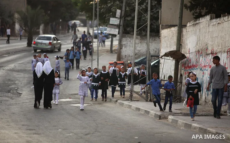 Palestinian students return back to their school in the morning of the first day of the new year study in Khan Younis in the southern Gaza Strip August 28, 2016. Photo by Ashraf Amra