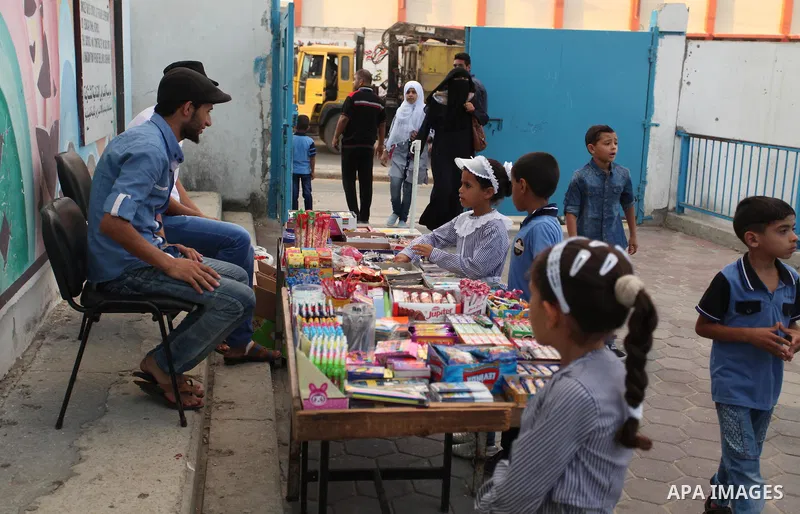 Palestinian students return back to their school in the morning of the first day of the new year study in Khan Younis in the southern Gaza Strip August 28, 2016. Photo by Ashraf Amra