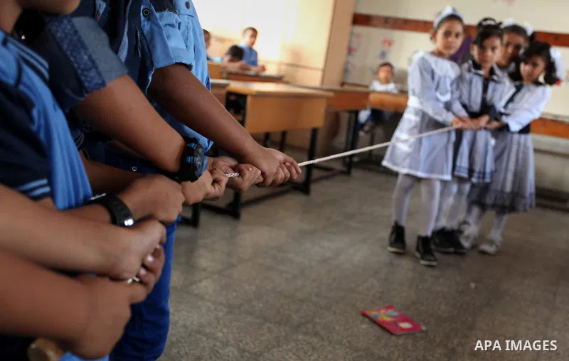 Palestinian schoolchildren play a game in a classroom on the first day of a new school year, at a United Nations-run school in Khan Younis in the southern Gaza Strip August 28, 2016. Photo by Ashraf Amra