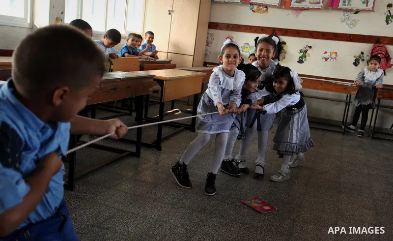 Palestinian schoolchildren play a game in a classroom on the first day of a new school year, at a United Nations-run school in Khan Younis in the southern Gaza Strip August 28, 2016. Photo by Ashraf Amra