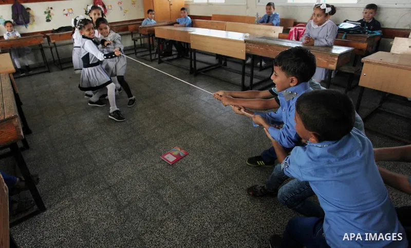 Palestinian schoolchildren play a game in a classroom on the first day of a new school year, at a United Nations-run school in Khan Younis in the southern Gaza Strip August 28, 2016. Photo by Ashraf Amra