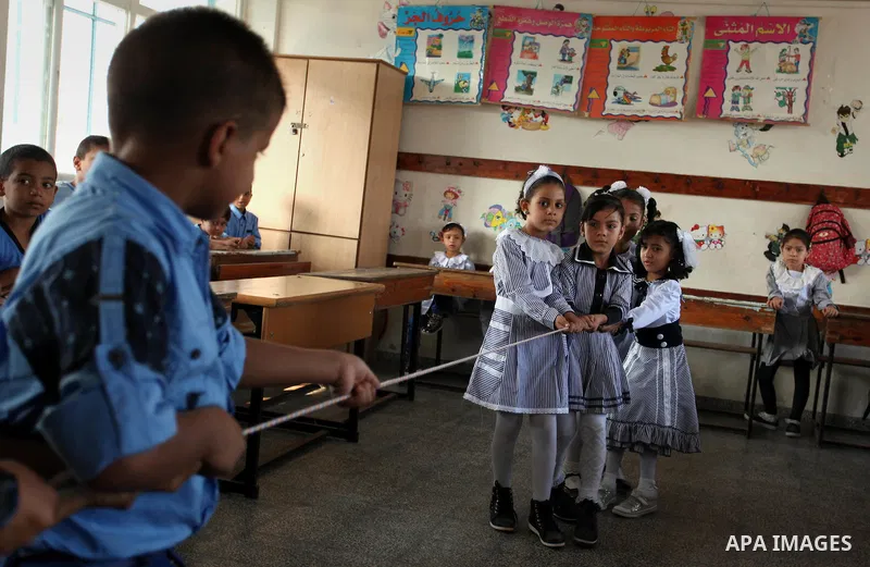 Palestinian schoolchildren play a game in a classroom on the first day of a new school year, at a United Nations-run school in Khan Younis in the southern Gaza Strip August 28, 2016. Photo by Ashraf Amra