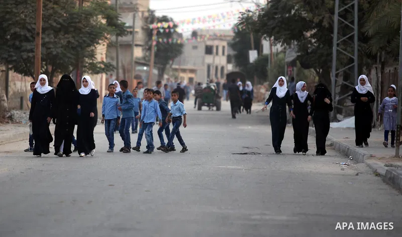Palestinian students return back to their school in the morning of the first day of the new year study in Khan Younis in the southern Gaza Strip August 28, 2016. Photo by Ashraf Amra