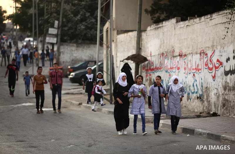 Palestinian students return back to their school in the morning of the first day of the new year study in Khan Younis in the southern Gaza Strip August 28, 2016. Photo by Ashraf Amra