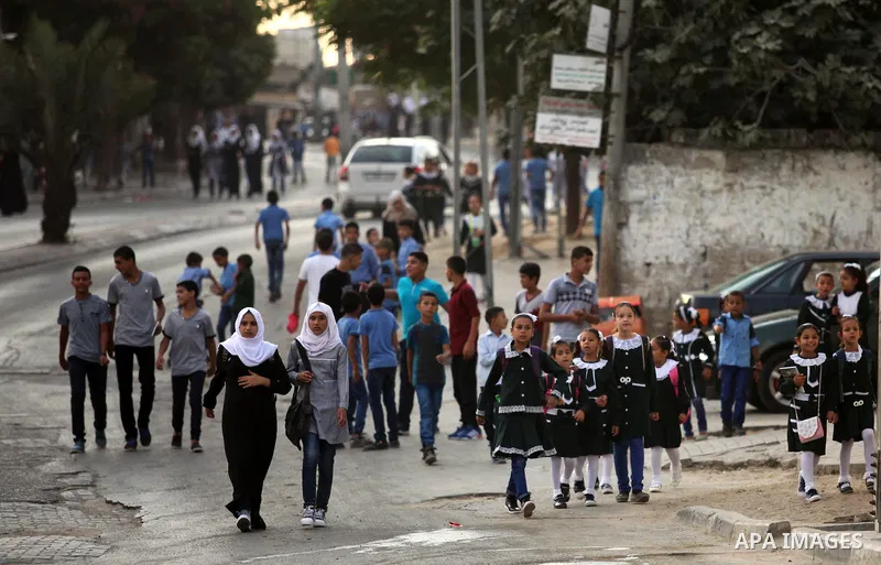 Palestinian students return back to their school in the morning of the first day of the new year study in Khan Younis in the southern Gaza Strip August 28, 2016. Photo by Ashraf Amra