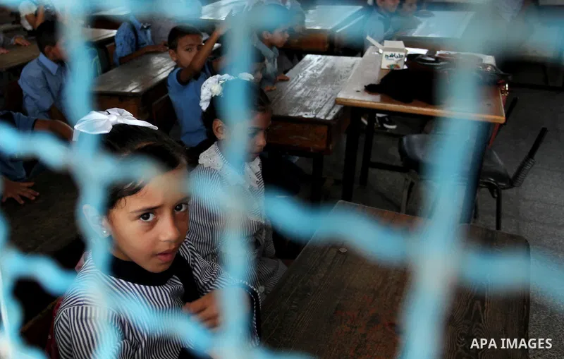 A Palestinian girl looks out of a classroom window as she attends a lesson on the first day of a new school year, at a United Nations-run school in Khan Younis in the southern Gaza Strip August 28, 2016. Photo by Ashraf...