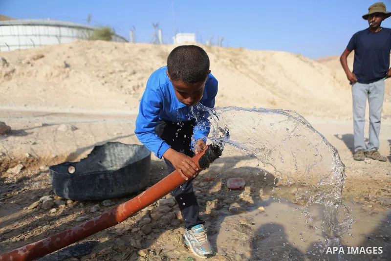 Palestinian Bedouin Students drink water at Arab Al-Ka'abneh school in Al-Mu'arrajat area near the West Bank city of Jericho, on the first day of a new school year on Aug. 28, 2016. Dozens of Palestinian children in the...