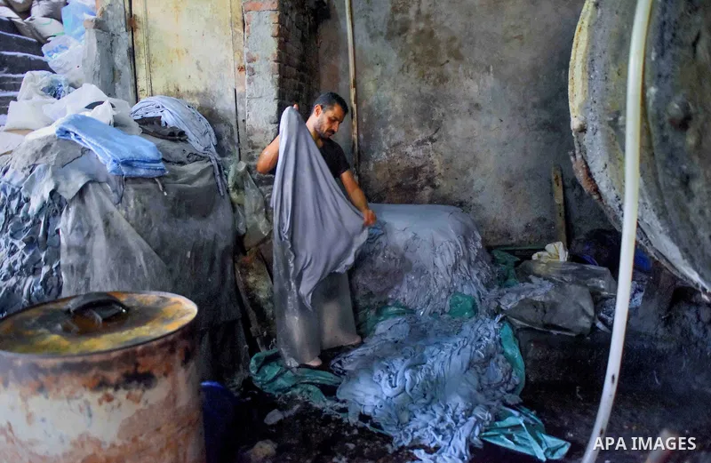 Egyptian leather tannery workers, salt the hides of animals before drying them, at a leather tannery, in Cairo, Egypt, on August 28, 2016. Photo by Amr Sayed
