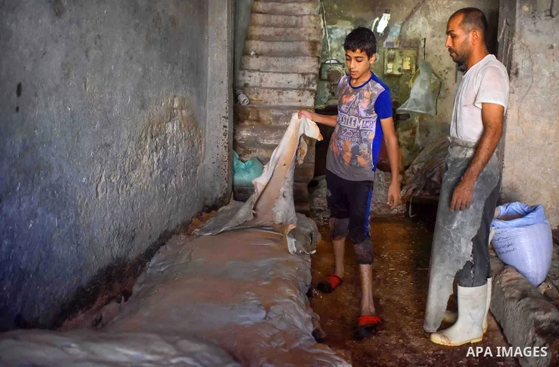 Egyptian leather tannery workers, salt the hides of animals before drying them, at a leather tannery, in Cairo, Egypt, on August 28, 2016. Photo by Amr Sayed