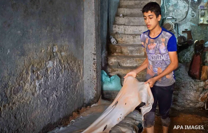 Egyptian leather tannery workers, salt the hides of animals before drying them, at a leather tannery, in Cairo, Egypt, on August 28, 2016. Photo by Amr Sayed