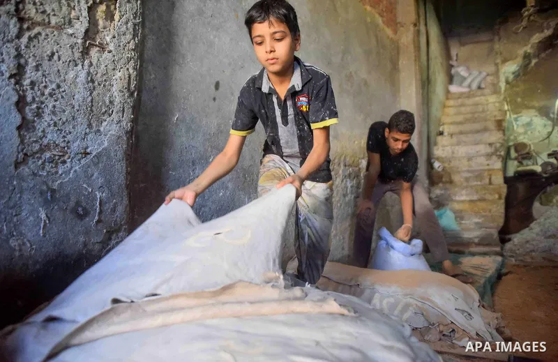 Egyptian leather tannery workers, salt the hides of animals before drying them, at a leather tannery, in Cairo, Egypt, on August 28, 2016. Photo by Amr Sayed