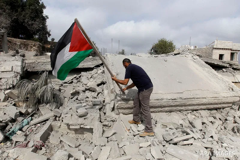 A Palestinian man inspects the rubble of the home of Mohammed Abed Almajid El-Amaira, a Palestinian accused of involvement in a shooting attack that led to the death of a rabbi, after it was destroyed by Israeli military...