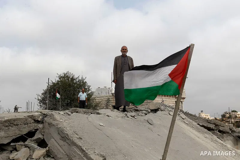 A Palestinian man inspects the rubble of the home of Mohammed Abed Almajid El-Amaira, a Palestinian accused of involvement in a shooting attack that led to the death of a rabbi, after it was destroyed by Israeli military...