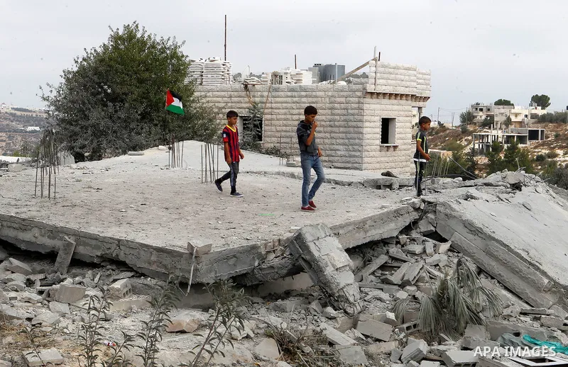 Palestinian youths inspect the rubble of the home of Mohammed Abed Almajid El-Amaira, a Palestinian accused of involvement in a shooting attack that led to the death of a rabbi, after it was destroyed by Israeli military...
