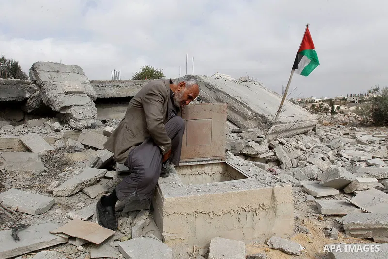 A Palestinian man inspects a well amidst the rubble of the home of Mohammed Abed Almajid El-Amaira, a Palestinian accused of involvement in a shooting attack that led to the death of a rabbi, after it was destroyed by Is...