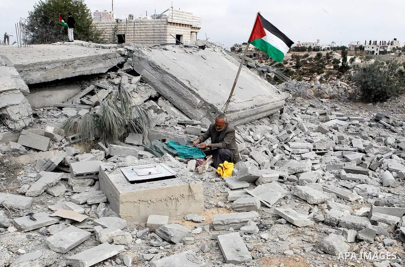 A Palestinian man inspects a well amidst the rubble of the home of Mohammed Abed Almajid El-Amaira, a Palestinian accused of involvement in a shooting attack that led to the death of a rabbi, after it was destroyed by Is...