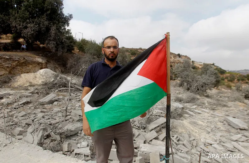 A Palestinian man inspects the rubble of the home of Mohammed Abed Almajid El-Amaira, a Palestinian accused of involvement in a shooting attack that led to the death of a rabbi, after it was destroyed by Israeli military...