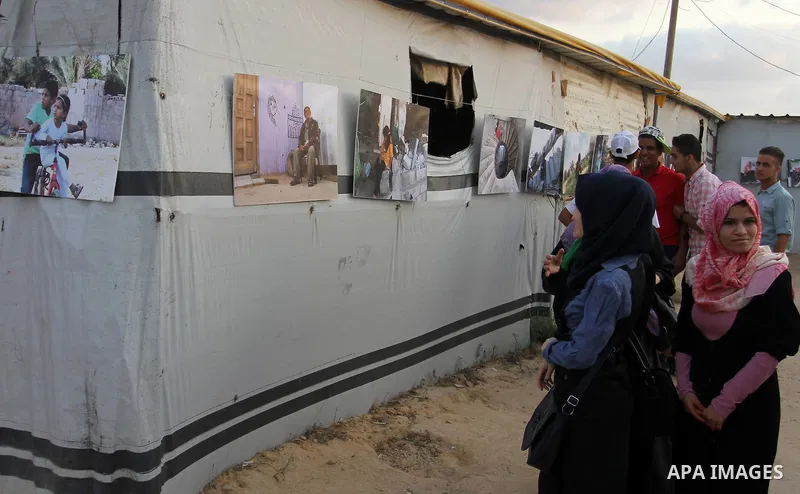 Palestinians attend the photographic exhibition "houses without columns", in Khuza'a, in the east of the town of Khan Younis in southern Gaza Strip, on August 30, 2016. Photo by Abed Rahim Khatib