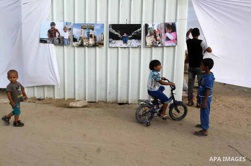 Palestinians attend the photographic exhibition "houses without columns", in Khuza'a, in the east of the town of Khan Younis in southern Gaza Strip, on August 30, 2016. Photo by Abed Rahim Khatib