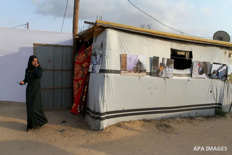 Palestinians attend the photographic exhibition "houses without columns", in Khuza'a, in the east of the town of Khan Younis in southern Gaza Strip, on August 30, 2016. Photo by Abed Rahim Khatib