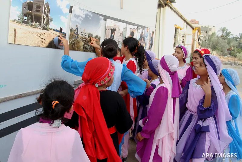 Palestinians attend the photographic exhibition "houses without columns", in Khuza'a, in the east of the town of Khan Younis in southern Gaza Strip, on August 30, 2016. Photo by Abed Rahim Khatib