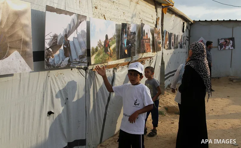 Palestinians attend the photographic exhibition "houses without columns", in Khuza'a, in the east of the town of Khan Younis in southern Gaza Strip, on August 30, 2016. Photo by Abed Rahim Khatib