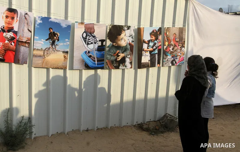 Palestinians attend the photographic exhibition "houses without columns", in Khuza'a, in the east of the town of Khan Younis in southern Gaza Strip, on August 30, 2016. Photo by Abed Rahim Khatib