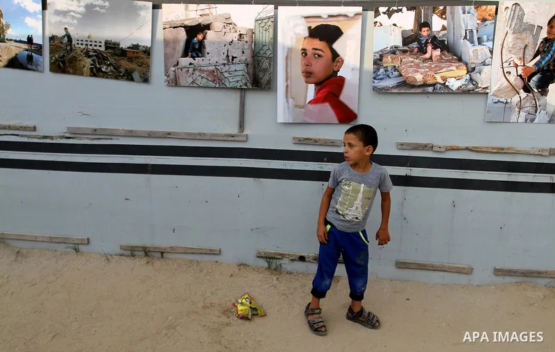 Palestinians attend the photographic exhibition "houses without columns", in Khuza'a, in the east of the town of Khan Younis in southern Gaza Strip, on August 30, 2016. Photo by Abed Rahim Khatib
