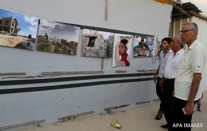 Palestinians attend the photographic exhibition "houses without columns", in Khuza'a, in the east of the town of Khan Younis in southern Gaza Strip, on August 30, 2016. Photo by Abed Rahim Khatib