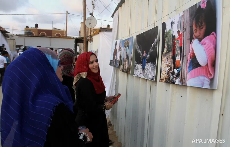 Palestinians attend the photographic exhibition "houses without columns", in Khuza'a, in the east of the town of Khan Younis in southern Gaza Strip, on August 30, 2016. Photo by Abed Rahim Khatib