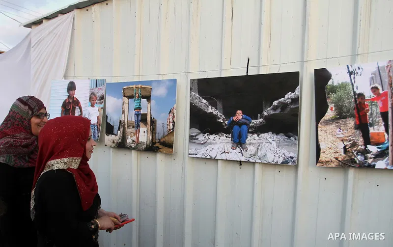 Palestinians attend the photographic exhibition "houses without columns", in Khuza'a, in the east of the town of Khan Younis in southern Gaza Strip, on August 30, 2016. Photo by Abed Rahim Khatib