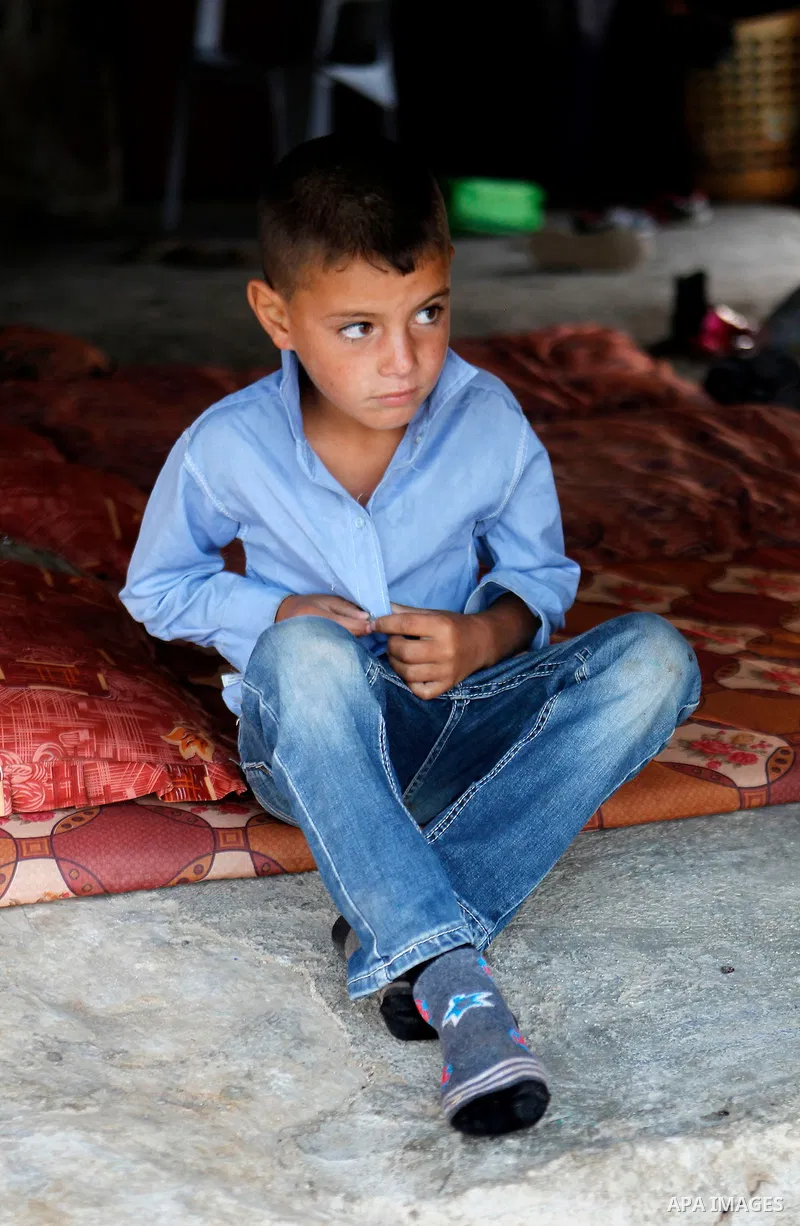 A Palestinian school student wears clothes before going to school in the West Bank village of Sosiya, south of Hebron, on September 1 2016, villages in Yatta area south of Hebron suffer from lack of schools and transport...