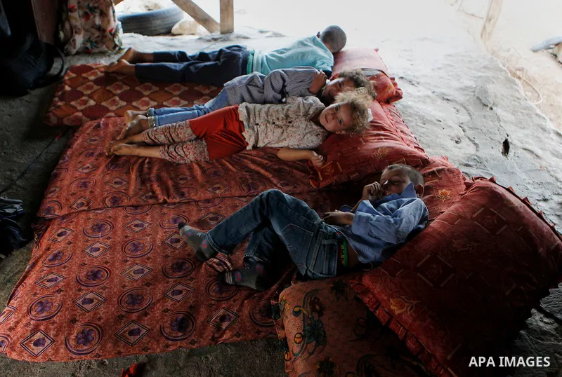 Palestinian school students lay on a mattress before going to school in the West Bank village of Sosiya, south of Hebron, on September 1 2016, villages in Yatta area south of Hebron suffer from lack of schools and transp...