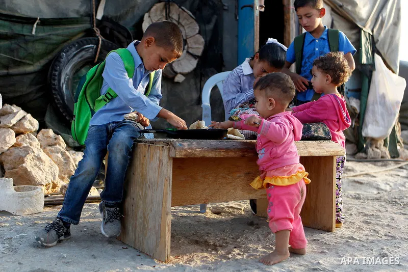 Palestinian school students eat breakfast before going to school in the West Bank village of Sosiya, south of Hebron, on September 1 2016, villages in Yatta area south of Hebron suffer from lack of schools and transporta...