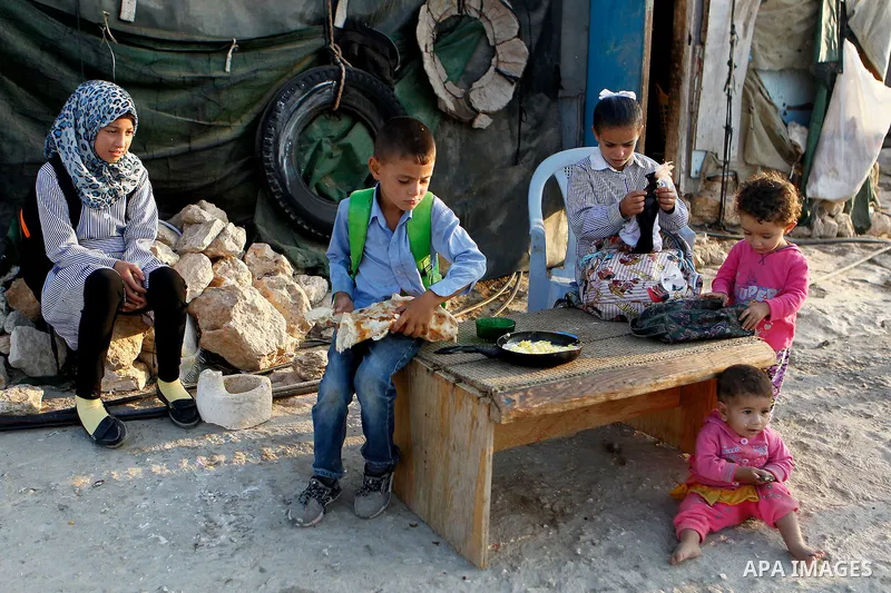 Palestinian school students eat breakfast before going to school in the West Bank village of Sosiya, south of Hebron, on September 1 2016, villages in Yatta area south of Hebron suffer from lack of schools and transporta...