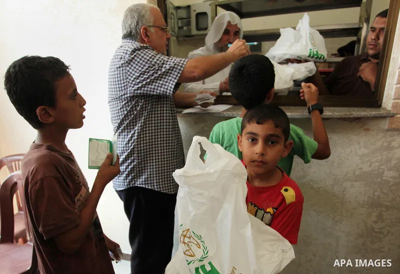 Palestinians receive free meals during the opening ceremony of a kitchen martyrs of the Freedom Flotilla (Mavi Marmara), which provides free meals for poor families, in Gaza city, on Sept. 01, 2016. Photo by Ashraf Amra