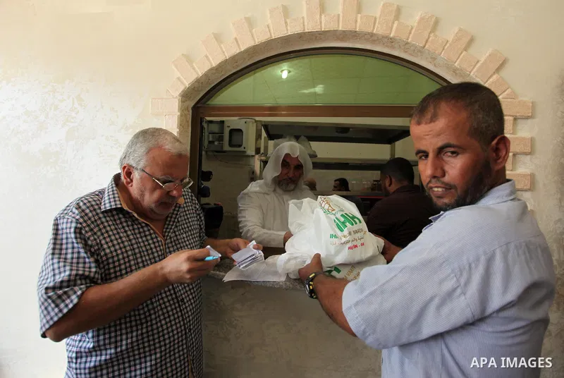 Palestinians receive free meals during the opening ceremony of a kitchen martyrs of the Freedom Flotilla (Mavi Marmara), which provides free meals for poor families, in Gaza city, on Sept. 01, 2016. Photo by Ashraf Amra