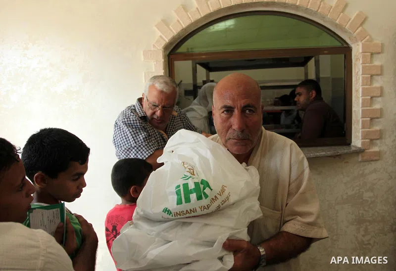 Palestinians receive free meals during the opening ceremony of a kitchen martyrs of the Freedom Flotilla (Mavi Marmara), which provides free meals for poor families, in Gaza city, on Sept. 01, 2016. Photo by Ashraf Amra