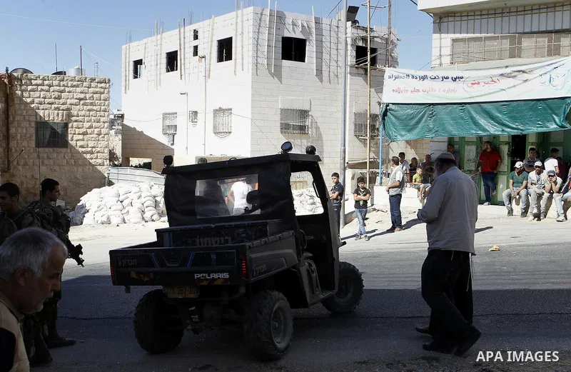 Israeli security forces stand guard after a Palestinian prevent the building of his house, near Kiryat Arba on the outskirts of the West Bank city of Hebron, on Sept. 02, 2016. Photo by Wisam Hashlamoun