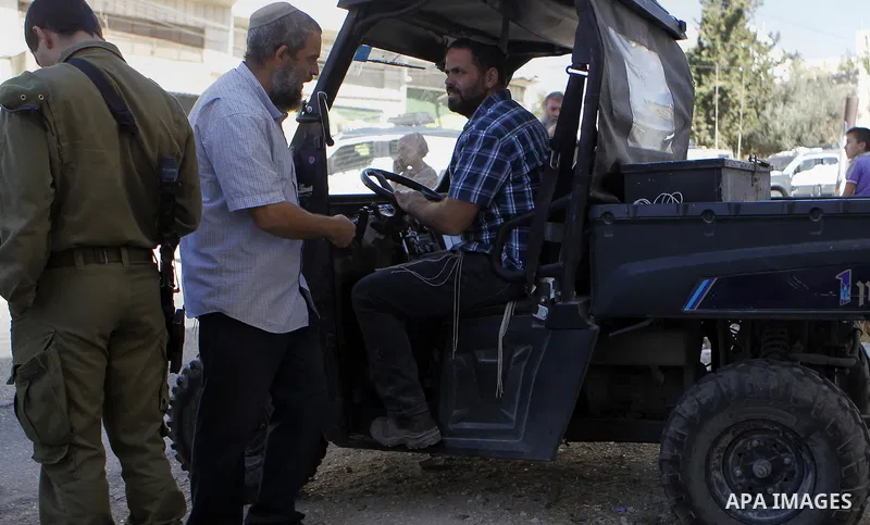 Israeli security forces stand guard after a Palestinian prevent the building of his house, near Kiryat Arba on the outskirts of the West Bank city of Hebron, on Sept. 02, 2016. Photo by Wisam Hashlamoun