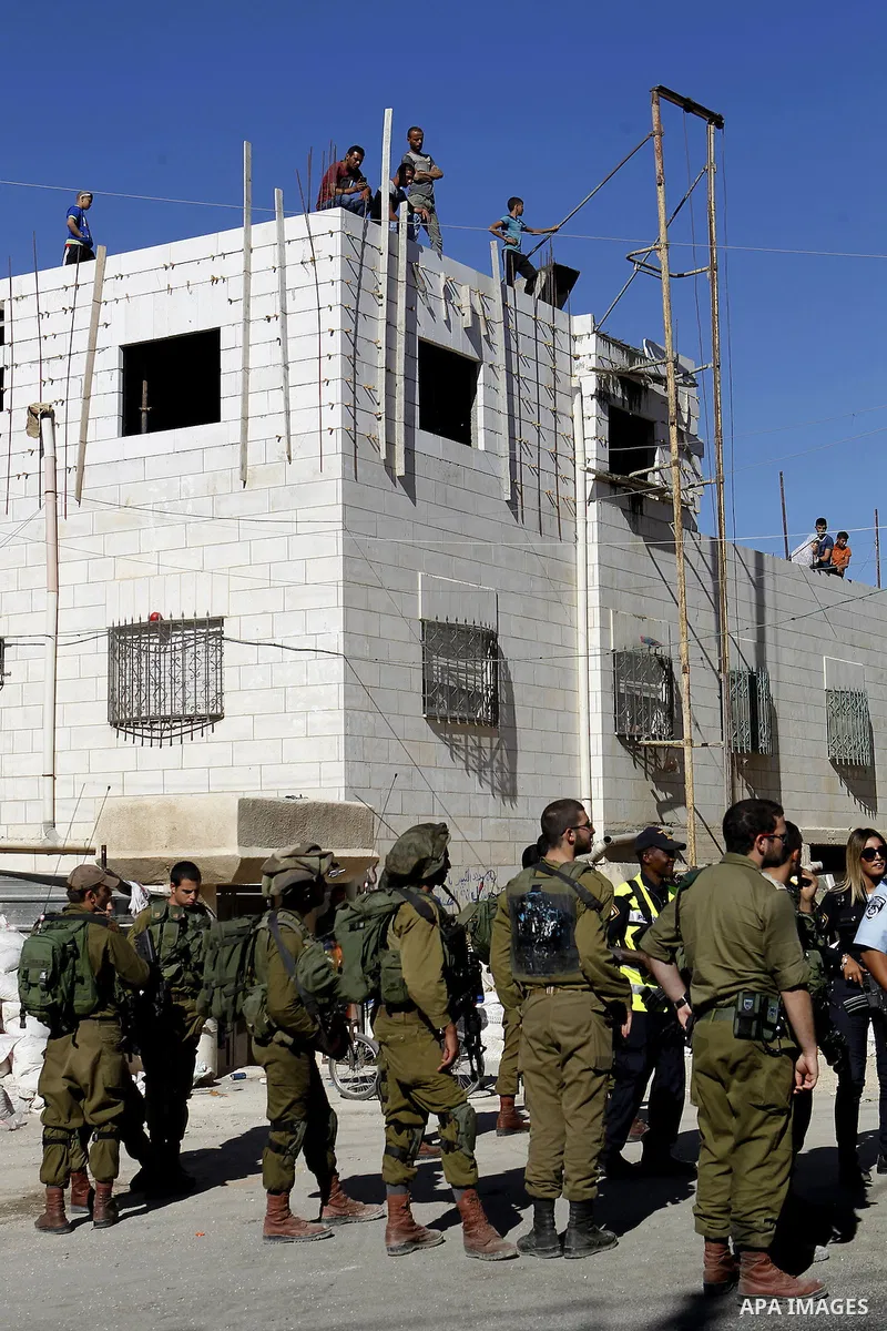 Israeli security forces stand guard after a Palestinian prevent the building of his house, near Kiryat Arba on the outskirts of the West Bank city of Hebron, on Sept. 02, 2016. Photo by Wisam Hashlamoun