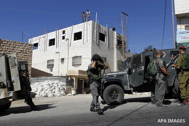 Israeli security forces stand guard after a Palestinian prevent the building of his house, near Kiryat Arba on the outskirts of the West Bank city of Hebron, on Sept. 02, 2016. Photo by Wisam Hashlamoun