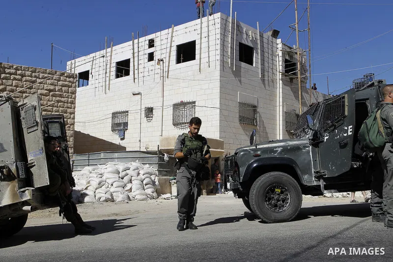 Israeli security forces stand guard after a Palestinian prevent the building of his house, near Kiryat Arba on the outskirts of the West Bank city of Hebron, on Sept. 02, 2016. Photo by Wisam Hashlamoun