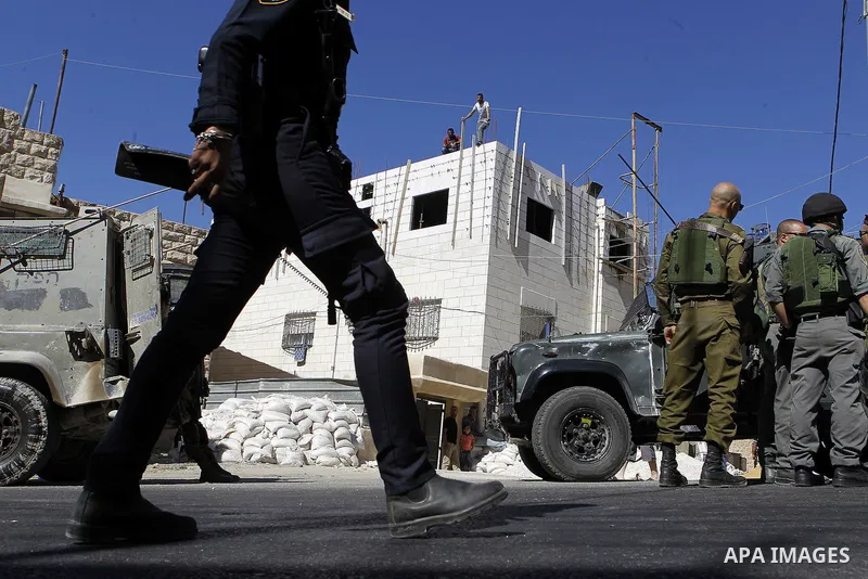 Israeli security forces stand guard after a Palestinian prevent the building of his house, near Kiryat Arba on the outskirts of the West Bank city of Hebron, on Sept. 02, 2016. Photo by Wisam Hashlamoun